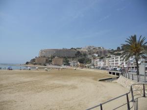 una playa de arena con edificios y gente en ella en Reihenhaus in Alcanar mit Garage, en Alcanar