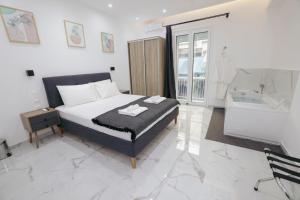1 dormitorio con cama y bañera en Apollo 2 bd jacuzzi suite en Athens