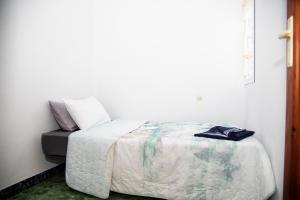 a bedroom with a bed and a white wall at Reihenhaus in Alcanar mit Garage in Alcanar