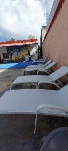 a row of white tables and chairs next to a building at La casa Jorge & Marvin in Cancún