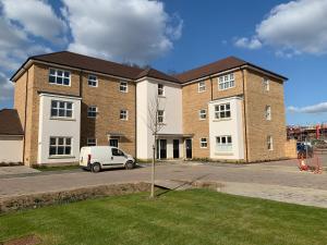 um edifício com uma carrinha branca estacionada em frente em Peterborough City Center One Bed apartment With Free Private Parking em Peterborough