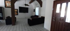 a living room with couches and a tv and a door at La casa Jorge & Marvin in Cancún