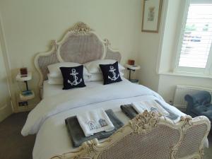 a bedroom with a white bed with pillows and towels at Whitstable Lets in Whitstable