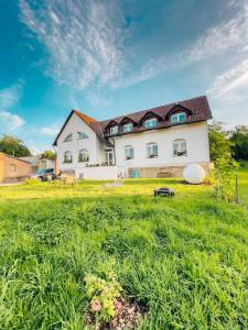 una gran casa blanca con un patio verde en Apartmány Maňová, 