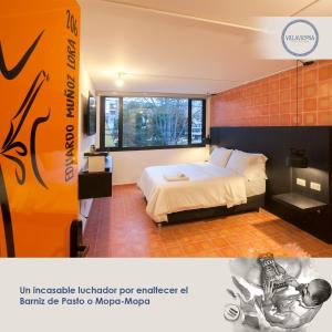 Villaviciosa Hotel Boutique في باستو: غرفة الفندق بسرير وملصق
