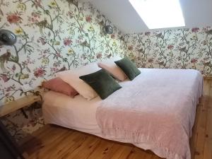 1 dormitorio con 1 cama con papel pintado con motivos florales en La Maison de Sylvie, chambres d'hôtes à Tarbes en Tarbes