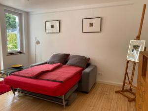 a bedroom with a bed with a red blanket at Ferienwohnung am Schölerberg in Osnabrück