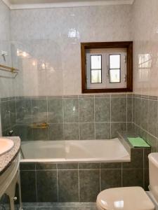 a bathroom with a tub and a toilet and a sink at Casa de S Bento in Rio Caldo