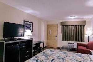 een hotelkamer met een bed, een bank en een televisie bij Motel 6 Nacogdoches, TX in Nacogdoches