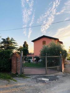 uma cerca em frente a uma casa cor-de-rosa em Villa Fiorella em Costacciaro