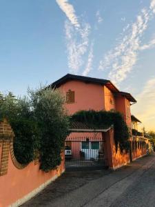 Villa Fiorella في Costacciaro: مبنى برتقالي مع بوابة على جانب شارع
