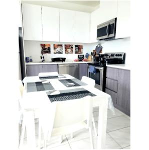 a kitchen with a white table and white chairs at Loft in Paradise in Nassau