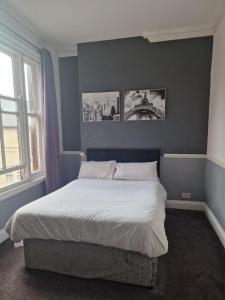 レスターにあるリージェンシー ホテルの壁に2枚の写真が飾られたベッドルームのベッド1台