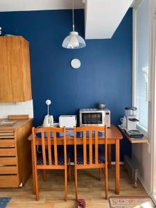 eine Küche mit einem Holztisch und einer blauen Wand in der Unterkunft Hot spot of Vaasa with City Hall views in Vaasa