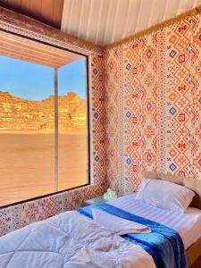 1 dormitorio con cama y ventana en WADi RUM ALi CAMP en Wadi Rum