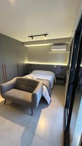 ein kleines Zimmer mit einem Bett und einem Sofa in der Unterkunft Studio Moema ao lado do Shopping e metro in São Paulo