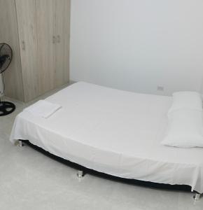 a bed in a room with a white bedsheet at T14 Acogedor Apartamento en conjunto con piscina y parqueadero in Neiva +15 photos