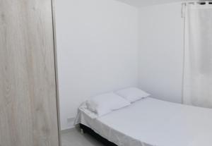 Habitación blanca con cama y espejo en Apartamento Neiva, en Neiva