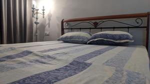 a bed with two pillows on top of it at APARTMENT - КВАРТИРА NEW in Tashkent