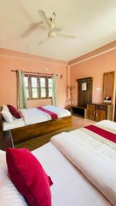 1 Schlafzimmer mit 2 Betten und roten Kissen in der Unterkunft Hotel Tree Tops- A Serene Friendly Hotel in Sauraha in Chitwan