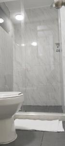 y baño blanco con ducha y aseo. en Apartamento Neiva, en Neiva