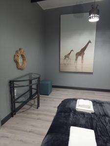 um quarto com uma cama e uma fotografia de duas girafas em Woodpecker Villa Guesthouse em Thabazimbi