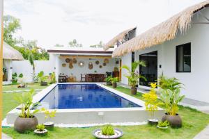 a villa with a swimming pool in front of a house at Panglao Lofts in Panglao Island