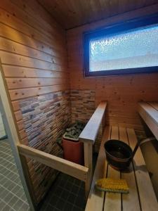 a sauna with a bucket and a window at Retro talo Kuhmon keskustassa in Kuhmo
