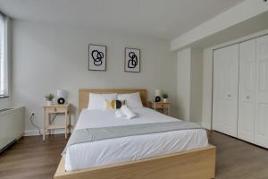 a white bedroom with a large bed with white sheets at Bright & Modern Apartment in Pentagon City in Arlington