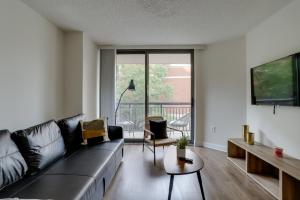 Bright & Modern Apartment in Pentagon City في أرلينغتون: غرفة معيشة مع أريكة وطاولة