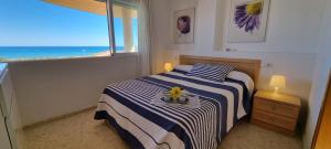a bedroom with a bed with a view of the ocean at Apartamento Junto al Mar in Oliva +22 photos