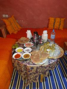 un tavolo con piatti di cibo su un divano di HÔTEL- KASBAH Aberdouz a Aït Hattab
