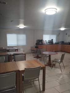 ウィルソンヴィルにあるQuality Inn & Suites Wilsonvilleのテーブルと椅子が備わる空き部屋、キッチンが備わる客室です。