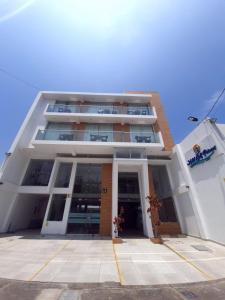 a large white building with a lot of windows at Hotel Golf Paracas in Paracas