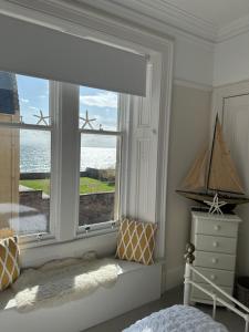 1 dormitorio con ventana y vistas al océano en Beautiful Elie Beach house,South St with Sea view, en Elie