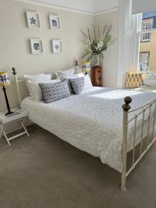 1 dormitorio con 1 cama grande con sábanas y almohadas blancas en Beautiful Elie Beach house,South St with Sea view, en Elie