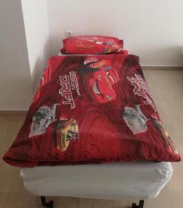 a bed with a red blanket on top of it at Apartment by the Sea,Neoi Epivates Beach, Thessaloniki in Neoi Epivates