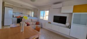 a kitchen and living room with a vase of flowers on a table at Apartamento Junto al Mar in Oliva