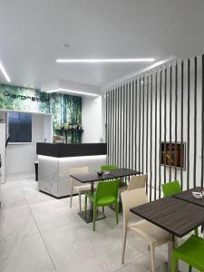 a dining room with tables and green chairs at Hotel Giardinetto Al Sant'Orsola in Bologna