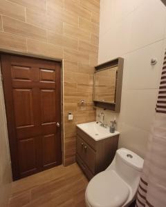 a bathroom with a toilet and a sink and a mirror at La casita de Carmen con terraza in Cuatrociénegas de Carranza