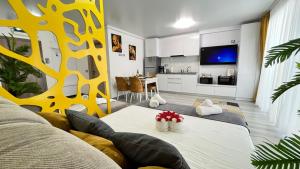 ein Wohnzimmer mit Sofa und Tisch in der Unterkunft Havana Studio-Alezzi Nord 10 (piscina&loc parcare) in Năvodari