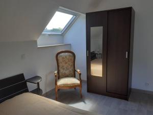 een slaapkamer met een bed, een stoel en een raam bij Gîte des Vergers in Saint-Pierre-du-Regard