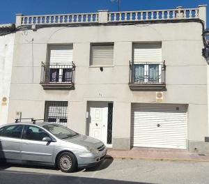 une voiture en argent garée devant un bâtiment dans l'établissement Casa Miravent, à Bellvei del Penedes