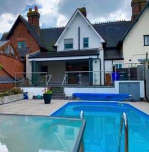 a swimming pool in front of a house at Beautiful Holiday Home Village Sleeps up to 6 in West Hallam