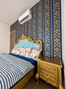ein Schlafzimmer mit einem blauen und goldenen Bett und einer Kommode in der Unterkunft Disneyland Theme DFB homestay 03 Gala City Armadale Residence in Kuching