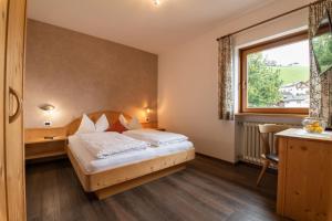 Habitación de hotel con cama y ventana en Garni Kostner en Ortisei