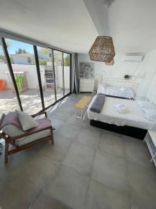 a bedroom with a large bed and a chair at MEDITERRANEAN HOUSE - Habitaciones Privadas en Casa Compartida in Mairena del Aljarafe