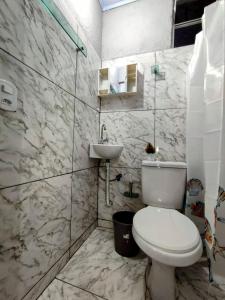 a bathroom with a toilet and a sink at Apartamentos SOLAR PALMER in Cabo Frio