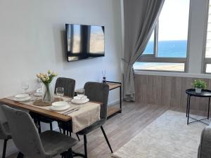 a dining room with a table and chairs with a view of the ocean at Apartments 1126 Colony Beach with Pool Bat Yam Tel Aviv in Bat Yam