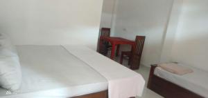 1 dormitorio con 2 camas y silla roja en WhyNot Guesthouse Ella en Ella